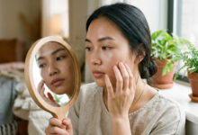 Retinol bao lâu có tác dụng - phụ nữ kiểm tra da trước gương