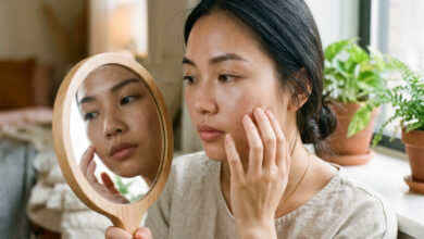 Retinol bao lâu có tác dụng - phụ nữ kiểm tra da trước gương